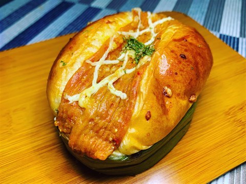 Soft bun topped with fish otah & cheese, wrapped with fresh pandan leaf & finished with dried parsley.