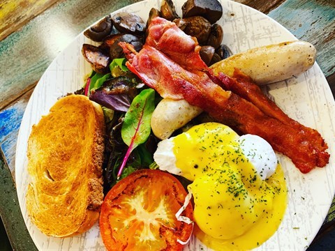 Poached egg, gourmet pork sausage, char-grilled streaky bacon, grilled tomato, sautéed mushrooms, roasted potatoes & toast slice.